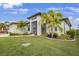 Home featuring a well maintained lawn and manicured landscaping, palm trees, and a two car garage at 19246 Moore Haven Ct, Port Charlotte, FL 33948