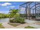 Relaxing screened lanai with comfortable seating, lush greenery, and views of the surrounding waterfront at 19246 Moore Haven Ct, Port Charlotte, FL 33948
