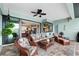Relaxing outdoor lanai featuring wicker furniture, a ceiling fan, and views into the kitchen and Gathering room at 19246 Moore Haven Ct, Port Charlotte, FL 33948