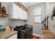 Functional laundry room with modern appliances, white cabinets, and counter space at 19246 Moore Haven Ct, Port Charlotte, FL 33948