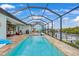 Inviting backyard pool with a screened enclosure, offering stunning views of the waterfront and lush landscaping at 19246 Moore Haven Ct, Port Charlotte, FL 33948
