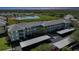 Scenic aerial view of a condo complex with covered parking, lush landscaping, and a tranquil pond at 2160 Heron Lake Dr # 201, Punta Gorda, FL 33983