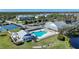 Aerial view of the community clubhouse, pool, tennis courts, and surrounding trees at 2160 Heron Lake Dr # 201, Punta Gorda, FL 33983
