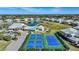 Aerial view showcasing the community clubhouse, pool, tennis and pickleball courts and pond at 2160 Heron Lake Dr # 201, Punta Gorda, FL 33983