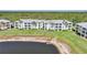 Aerial view of the condo buildings overlooking a pond, surrounded by green lawns at 2160 Heron Lake Dr # 201, Punta Gorda, FL 33983