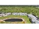 Aerial view of multiple condo buildings, a pond, and lush green trees at 2160 Heron Lake Dr # 201, Punta Gorda, FL 33983