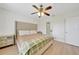 Bright bedroom features wood floors, a tan upholstered headboard, and a brass ceiling fan at 2160 Heron Lake Dr # 201, Punta Gorda, FL 33983