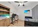 This bedroom features wood floors, a ceiling fan, a wooden bookcase, and a gaming setup at 2160 Heron Lake Dr # 201, Punta Gorda, FL 33983