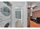 Hallway showing the bathroom and a laundry closet with a stacked washer and dryer at 2160 Heron Lake Dr # 201, Punta Gorda, FL 33983