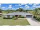 Charming single-story home featuring a well-manicured lawn, tropical landscaping, and an attached two-car garage at 2193 Beacon Dr, Port Charlotte, FL 33952