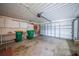 A spacious garage featuring storage shelves, overhead door, and a clean concrete floor at 2193 Beacon Dr, Port Charlotte, FL 33952