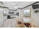 Kitchen with dining area, featuring white cabinets, tile floors and a window overlooking the garage at 2193 Beacon Dr, Port Charlotte, FL 33952