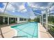 The screened-in pool is surrounded by a spacious patio and lush landscaping at 2193 Beacon Dr, Port Charlotte, FL 33952