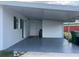Exterior view of carport featuring double doors and an adjacent small shed at 230 Waterway Cir Ne, Port Charlotte, FL 33952