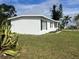 Charming single-story home with white exterior, black shutters, and well-maintained lawn at 230 Waterway Cir Ne, Port Charlotte, FL 33952