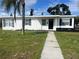 Charming single-story home with a well-manicured lawn and a walkway leading to the front door at 230 Waterway Cir Ne, Port Charlotte, FL 33952