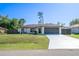 Charming single-Gathering home with a well-maintained lawn and a two-car garage under a clear blue sky at 2405 Mistleto Ln, North Port, FL 34286