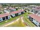 Aerial view of a condominium community with landscaping, a pond, and a pool at 25100 Sandhill Blvd # F-203, Punta Gorda, FL 33983