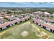 Aerial view of the community showcasing the tranquil lake and well-maintained landscaping at 25100 Sandhill Blvd # F-203, Punta Gorda, FL 33983