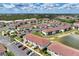 An aerial view of a condo community with multiple buildings, a pond, and parking at 25100 Sandhill Blvd # F-203, Punta Gorda, FL 33983