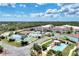 Aerial view of the community showcasing amenities like a pool, tennis courts, and manicured landscaping at 25100 Sandhill Blvd # F-203, Punta Gorda, FL 33983