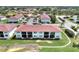 An aerial view of condominiums with mature trees and a pond at 25100 Sandhill Blvd # F-203, Punta Gorda, FL 33983