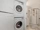 Bathroom featuring a glass shower, vanity with sink, toilet, and stacked washer and dryer at 25100 Sandhill Blvd # F-203, Punta Gorda, FL 33983