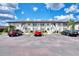 Attractive condo building featuring multiple units, stairs to the second floor, and ample parking spaces at 25100 Sandhill Blvd # F-203, Punta Gorda, FL 33983