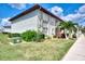 Exterior of condo unit with manicured lawn and landscaping at 25100 Sandhill Blvd # F-203, Punta Gorda, FL 33983