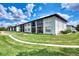 Exterior of property surrounded by vibrant green grass and gorgeous blue sky at 25100 Sandhill Blvd # F-203, Punta Gorda, FL 33983