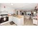 Bright kitchen featuring white cabinets, light countertops, a range and tiled flooring open to the living room at 25100 Sandhill Blvd # F-203, Punta Gorda, FL 33983