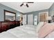 Comfortable main bedroom with ceiling fan, a large bed with white duvet, and bedside tables with lamps at 25100 Sandhill Blvd # F-203, Punta Gorda, FL 33983