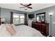 Bright bedroom features a large bed with a dark wood frame, matching bedside tables, and a ceiling fan at 25100 Sandhill Blvd # F-203, Punta Gorda, FL 33983