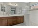 Bright bathroom featuring a double sink vanity and a glass-enclosed shower with decorative tile accents at 253 Marcheno Way, Nokomis, FL 34275
