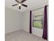 Serene bedroom with carpet, ceiling fan, and window with purple curtains offering a peaceful retreat at 253 Marcheno Way, Nokomis, FL 34275