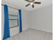 Inviting bedroom with soft carpet, modern ceiling fan, and blue curtains framing a window at 253 Marcheno Way, Nokomis, FL 34275