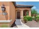 Close-up of an inviting front entrance with a covered porch, stylish light fixture, and manicured landscaping at 253 Marcheno Way, Nokomis, FL 34275