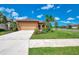 Charming single-story home with a well-manicured lawn, inviting landscape, and attached two car garage at 253 Marcheno Way, Nokomis, FL 34275