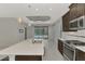 The kitchen island has stainless steel appliances, a sink, and overlooks the outdoor pool at 253 Marcheno Way, Nokomis, FL 34275