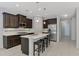 The kitchen features a center island with dark wood cabinets and stainless steel appliances at 253 Marcheno Way, Nokomis, FL 34275