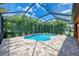 Beautiful screened-in pool surrounded by lush greenery and a peaceful blue sky at 253 Marcheno Way, Nokomis, FL 34275