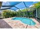 Inviting screened-in pool area with a lush tropical landscape and serene blue sky at 253 Marcheno Way, Nokomis, FL 34275