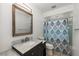 Updated bathroom featuring a marble countertop vanity and a shower with patterned curtain at 25449 Doredo Dr, Punta Gorda, FL 33955