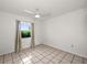 Bright bedroom with neutral tile flooring, ceiling fan, and a window with pleasant view at 25449 Doredo Dr, Punta Gorda, FL 33955