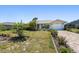 Well-manicured front yard with a paver driveway leading to a charming home with turquoise accents at 25449 Doredo Dr, Punta Gorda, FL 33955