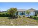 Charming single-story home featuring lush landscaping, turquoise shutters, and a well-maintained lawn at 25449 Doredo Dr, Punta Gorda, FL 33955