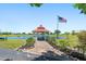 Charming gazebo overlooking a scenic lake with an American flag waving proudly on a clear day at 25449 Doredo Dr, Punta Gorda, FL 33955