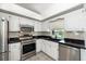 Bright kitchen featuring stainless steel appliances, white cabinetry, and modern countertops at 25449 Doredo Dr, Punta Gorda, FL 33955