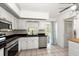 Well-lit kitchen featuring white cabinets, black countertops, stainless steel appliances, and tiled floors at 25449 Doredo Dr, Punta Gorda, FL 33955