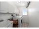 Bright laundry room with white cabinetry, modern washer/dryer and a utility sink at 25449 Doredo Dr, Punta Gorda, FL 33955